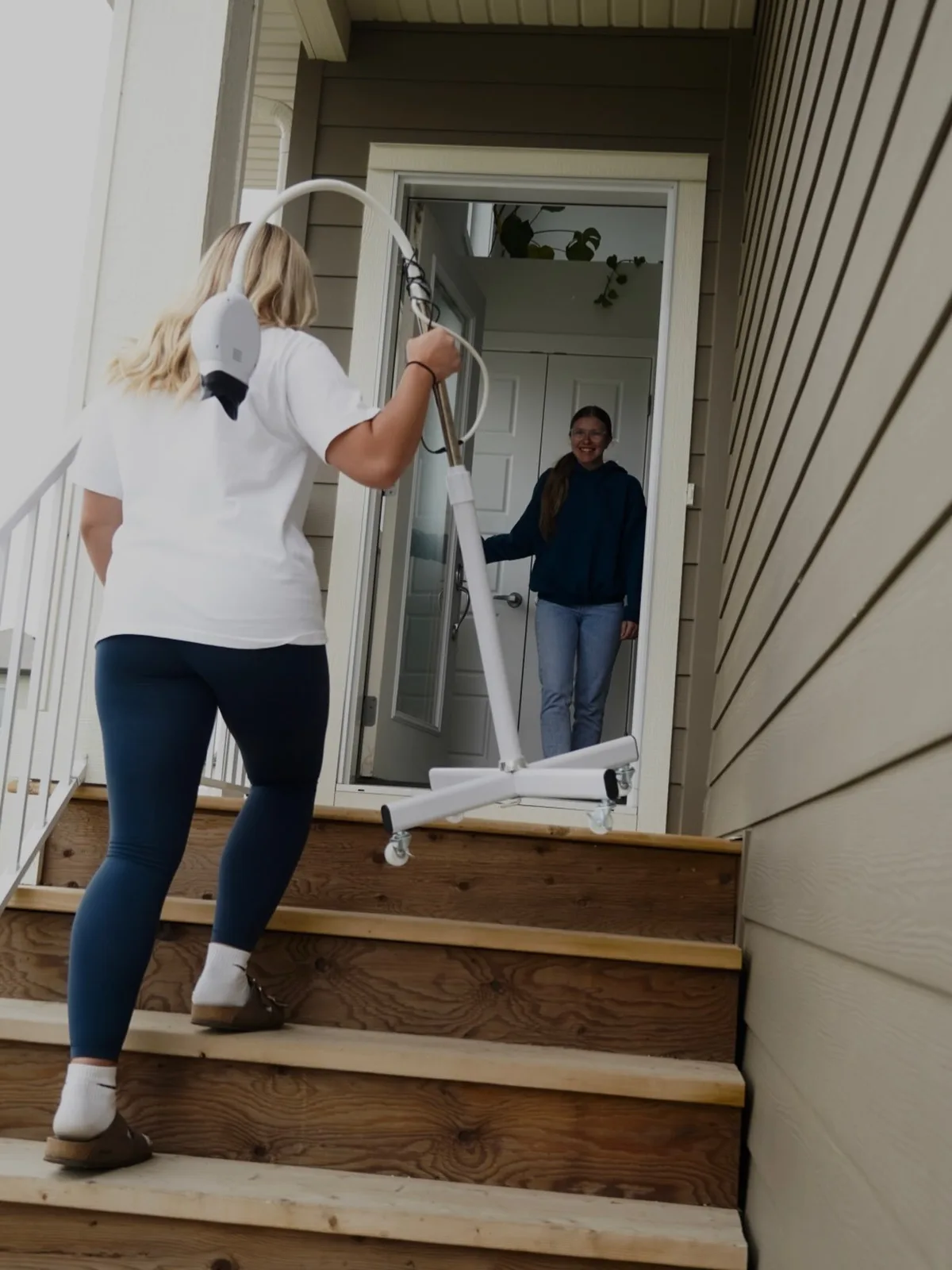 ProElite carrying the whitening lamp up the front steps into a client's home